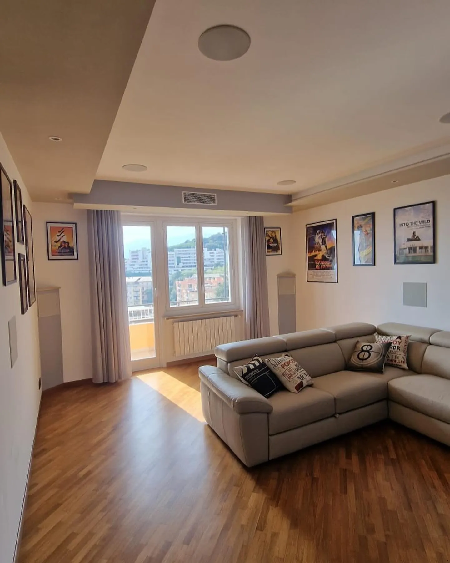 Soggiorno ristrutturato con divano angolare, parquet e controsoffitto con faretti