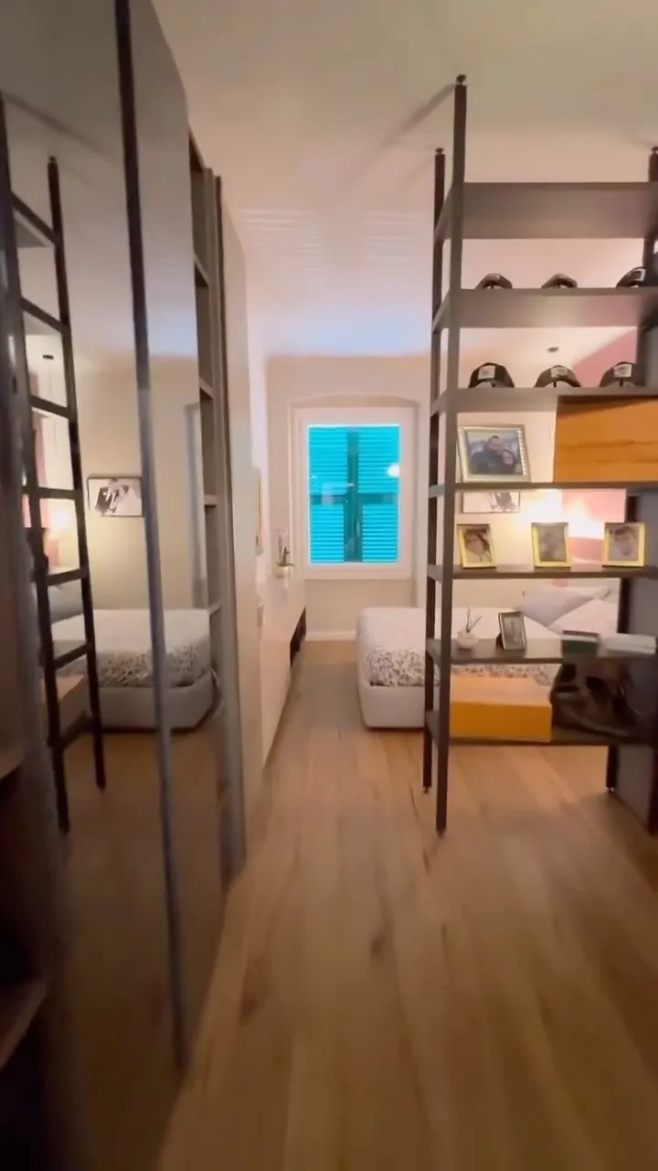 Corridoio con porte a filo che conduce alla camera con libreria su misura