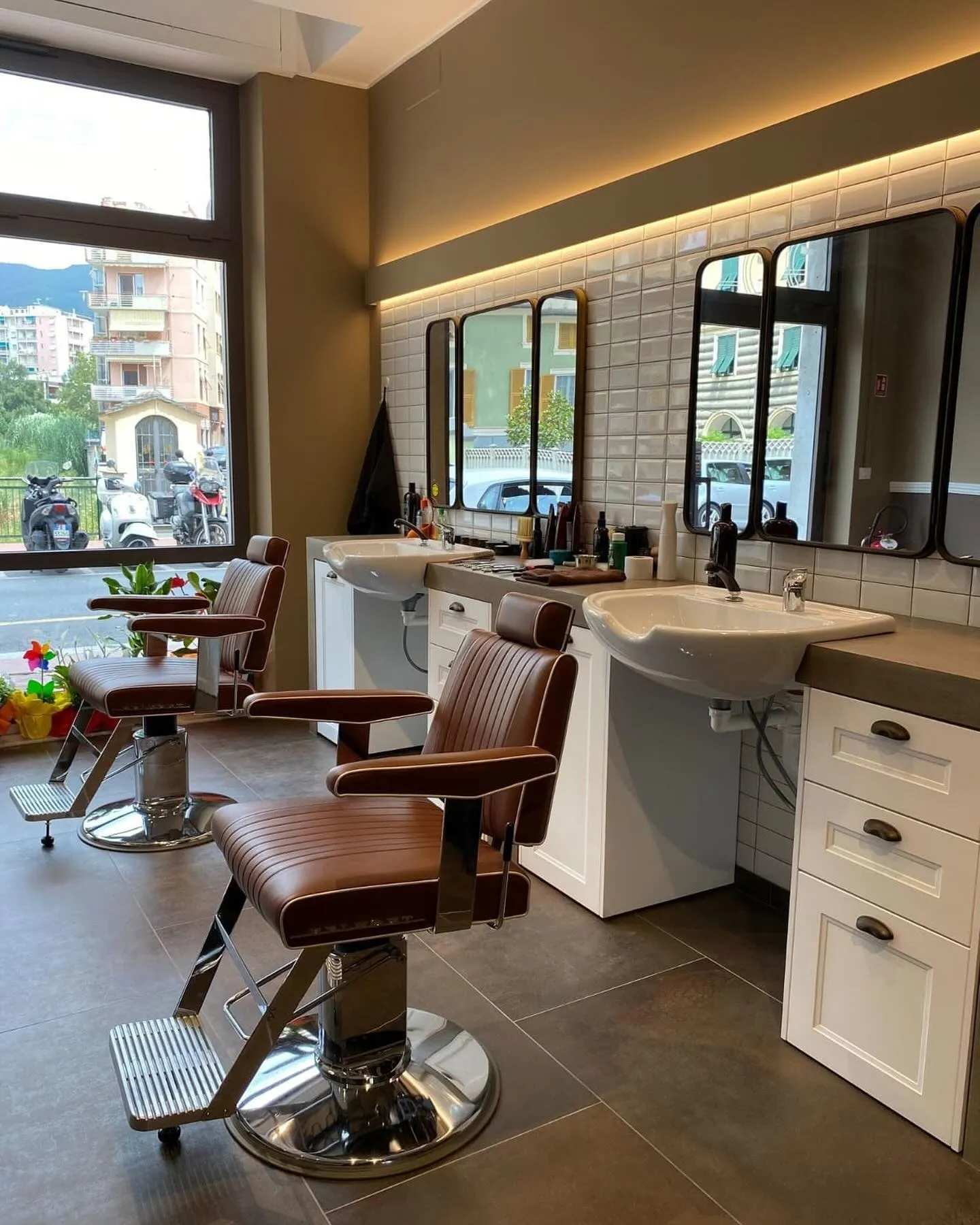 Postazioni del barber shop con lavabi e boiserie bianca
