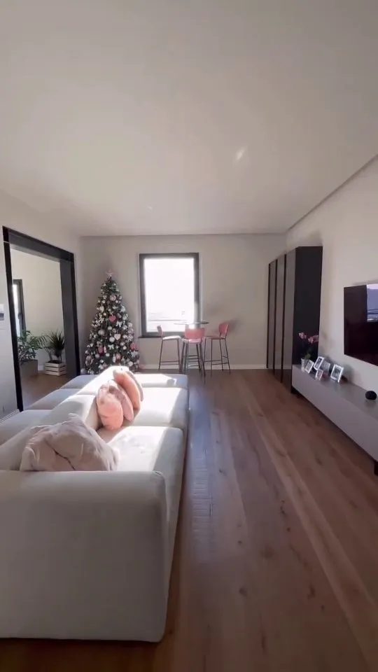 Soggiorno ristrutturato con parquet scuro e divano chiaro